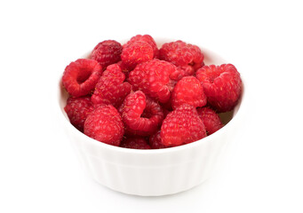 Raspberries are collected in a white Cup on a white background. Berry background. The concept of natural products.