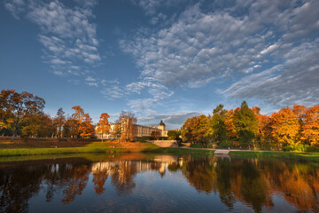 Fototapeta na wymiar A palace and park in the city of Gatchina in the Leningrad Region is reflected in the water during a golden autumn.