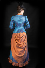 A young Victorian woman wearing an 1880s ensemble
