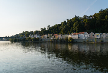 Fototapeta na wymiar Panoramic view of houses reflecting on the Danube River in summer, Passau, Germany