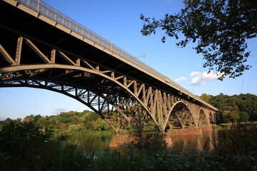 View of steel arch bridge Strawberry Mansion Bridge crossing the Schuylkill River in Fairmount Park under sunset  in Philadelphia, Pennsylvania, USA