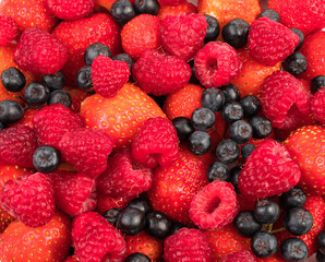 Berry background of raspberries, strawberries, chokeberry. The concept of proper nutrition.