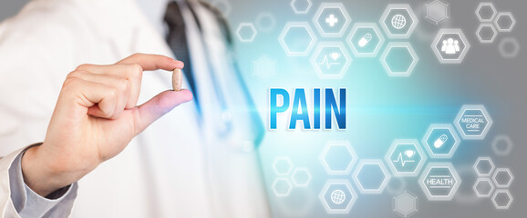 Close-up of a doctor giving you a pill with PAIN inscription, medical concept