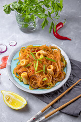  Asian glass noodles with squid and vegetables on a plate on the table