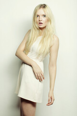 Obraz premium young fashion woman in white dress posing in studio