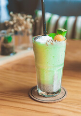 Cold fresh melon smoothies with sesame, coconut topping on glass..Healthy smoothie vitamins drink with melon and cantaloupe shake with yogurt for breakfast on wooden table, .summer drink beverage.