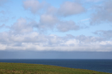 Fototapeta na wymiar Coastal view of clouds, meadows and Pacific Ocean (Nemuro, Hokkaido, Japan)