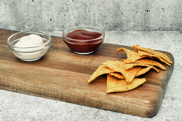 Corn cheese, snacks with sauce on a wooden stand. Beer snack, dish on the menu. Close up.