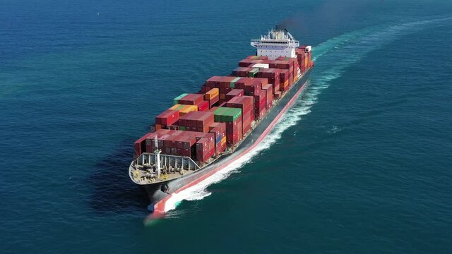 Large loaded Container Ship sailing across the ocean, Aerial view.