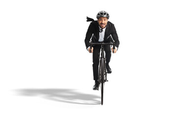 Young businessman in a suit riding a bicycle towards the camera