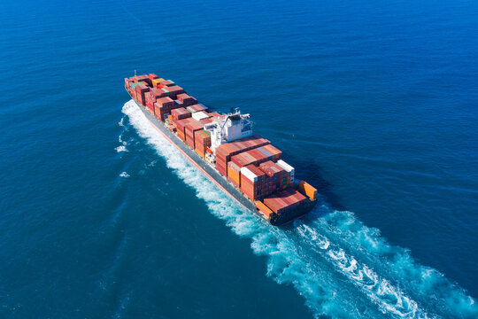 Zim Tarragona loaded Container ship cruising away from port, Aerial view.
