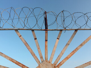 Barbed wire and rusty iron fence, protected area.