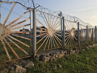 Barbed wire and rusty iron fence, protected area.