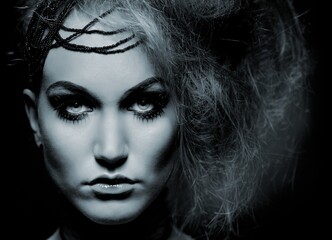 Closeup portrait of young woman in scary makeup, looking at camera.