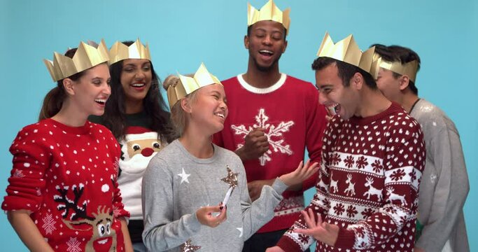 Studio, slow motion, group of friends in festive clothes laughing