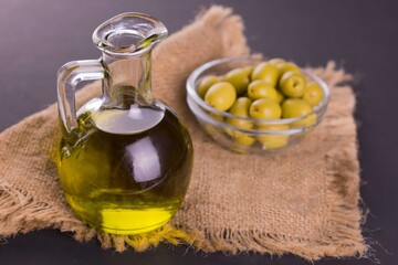 
Decanter with olive oil and olives in a bowl.
Close-up.