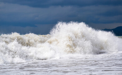 Storm at sea, waves crash on rocks.