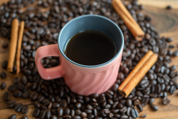 cup of coffee alongwith beans and cinnamon stick