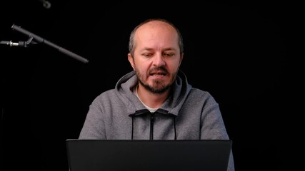 Influencer filming intro for podcast in professional studio on black background. Social media podcast or vlogging concept
