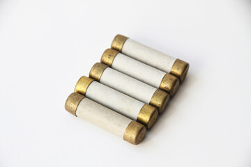 Old electric high-voltage fuses on a white background.