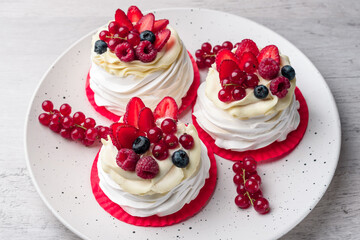 Pavlova meringue cake with cream and raspberries, blueberries, strawberries, currants