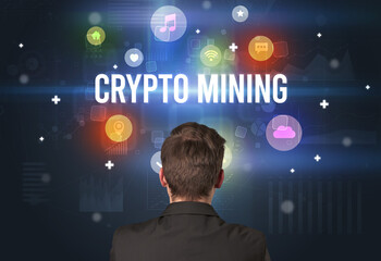 Rear view of a businessman with CRYPTO MINING inscription, modern technology concept