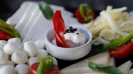 Dairy products and vegeatables in breakfast table. 
kashar cheese,  ,bryndza, cottage cheese.  Close up view.