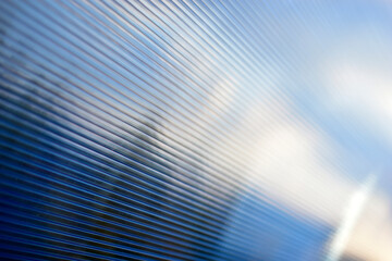 Blue surface of striped polycarbonate with a reflection of the blue distance of the city