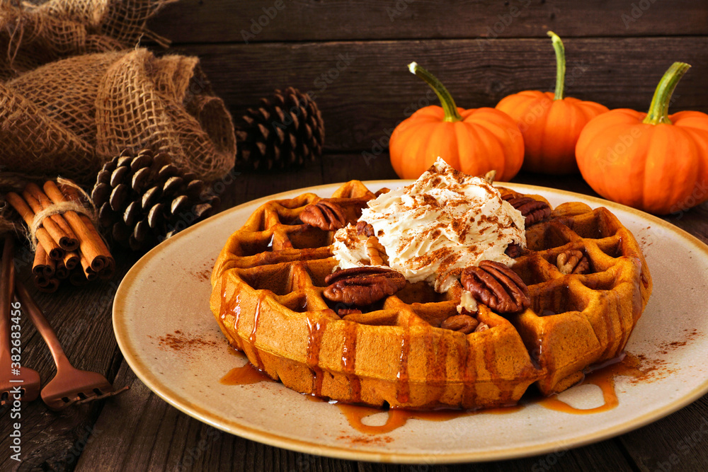 Poster pumpkin spice waffle with whipped topping, caramel and pecans. side view table scene with a dark woo