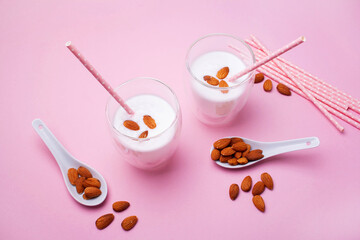 Two glasses of almond milk on a pink background. Lactose-free milk. Vegetarian food