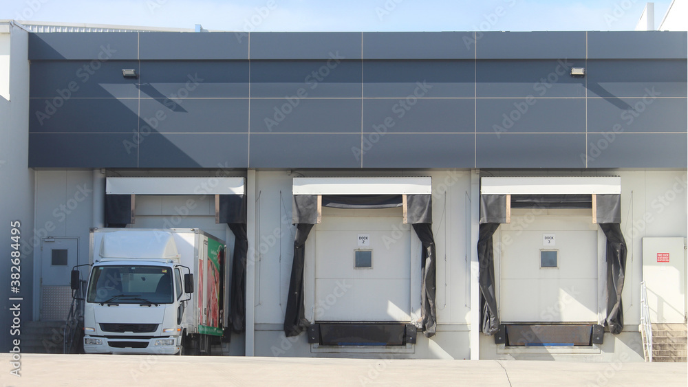 Wall mural Three refrigerated truck loading docks of a modern food manufacturing facility. Western Sydney Australia