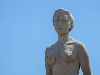 Fototapeta na wymiar standing sculpture statue de femme avec ciel