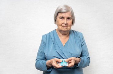 Elderly woman with pills in a hands