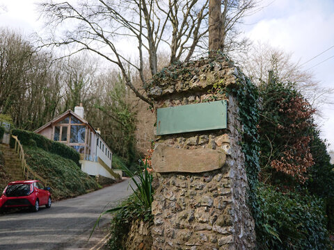 Two empty old wooden house signs on a stone posts in a residential area