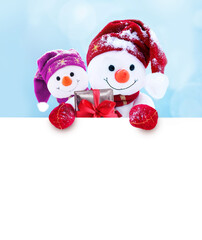 Two little snowmen the girl and the boy in caps and scarfs on snow in the winter. Background with a funny snowman. Christmas card.