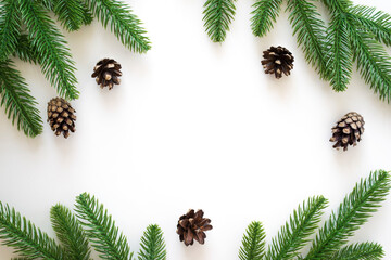 Fototapeta na wymiar New Year background with green fir branches and pine cones isolated on white. Winter or Christmas template for your design with copy space.