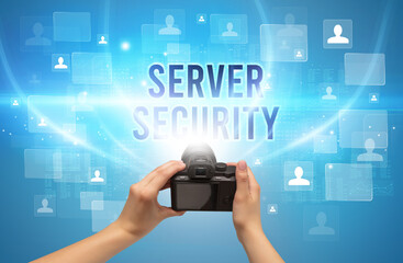 Close-up of hand holding camera with SERVER SECURITY inscription, video surveillance concept