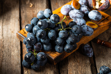 Grapes on a old wooden table. Blue grape. Black grape. Vine grape. Still life of food.