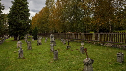 Naklejka premium Old revitalized cemetery in autumn colored forrest, Knizeci Plane, Sumava National Park
