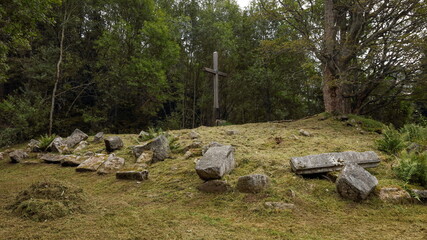 Tall wooden cross standing at a place of former church destroyed in 1960s by communist regime, Knizeci Plane, Sumava National Park, Czech Republic