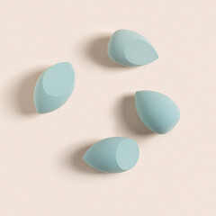 blue cosmetic makeup sponge on a beige nude background. A set of sponges of different shapes. Tool for applying foundation. Nobody. Flat lay