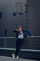 Pretty girl with long dark hair and red lips. Fashion young stylish hipster girl on street.