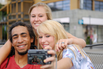 Three friends taking a self protrait with a digital camera