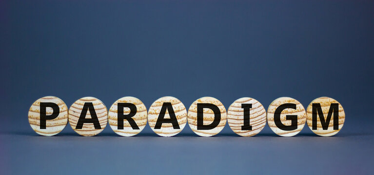 Concept word 'paradigm' on wooden circles on a beautiful grey background. Business concept. Copy space.
