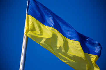 European union flag and ukrainian flag fluttering against blue sky background