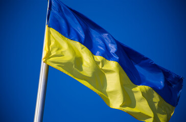 European union flag and ukrainian flag fluttering against blue sky background