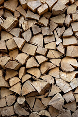 Stacks of firewood in the sawmill. Storage of wood. Firewood background vertical