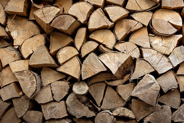 Fototapeta premium Stacks of firewood in the sawmill. Storage of wood. Firewood background