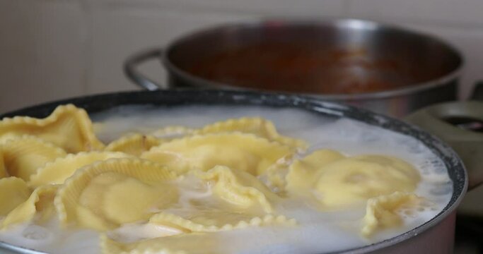 Prepare a first course for a lunch in an Italian house. Homemade ravioli with flour and stuffed with cheese and raw ham.