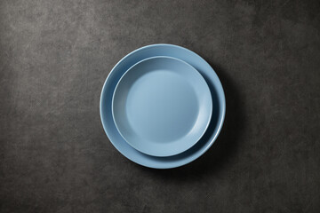two beautiful blue modern plates on a dark gray concrete background, top view
